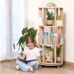Girl reading a book from the rotating bookshelf tower beside a window