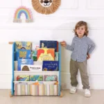 Child standing beside the front-facing book display rack