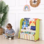 Toddler reading a picture book from the sling book rack at floor level
