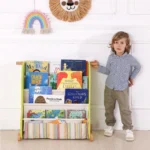 Child standing beside the front-facing book display rack