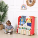 Toddler reading a picture book from the sling book rack at floor level