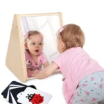 Two babies exploring the double-sided sensory mirror together