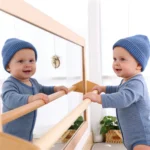 Baby holding the 5-position handrail while looking in the mirror