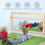 Children lying on the floor playing in front of the large sensory mirror