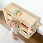 Baby standing while holding the cabinet handrail beside the storage cubbies