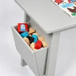 Close-up of the grey table's side storage cubby with toys inside