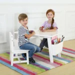 Two children playing at the white kids table set