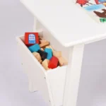 Close-up of the white table's side cubby filled with toys