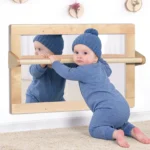Toddler practising standing with both hands on the pull-up bar