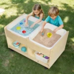 Two children playing at the outdoor sand and water station