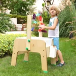 Child playing at the sand and water table in a garden