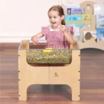 Child playing at the see-through sensory table indoors