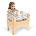 Child playing with sand and water in the transparent sensory table